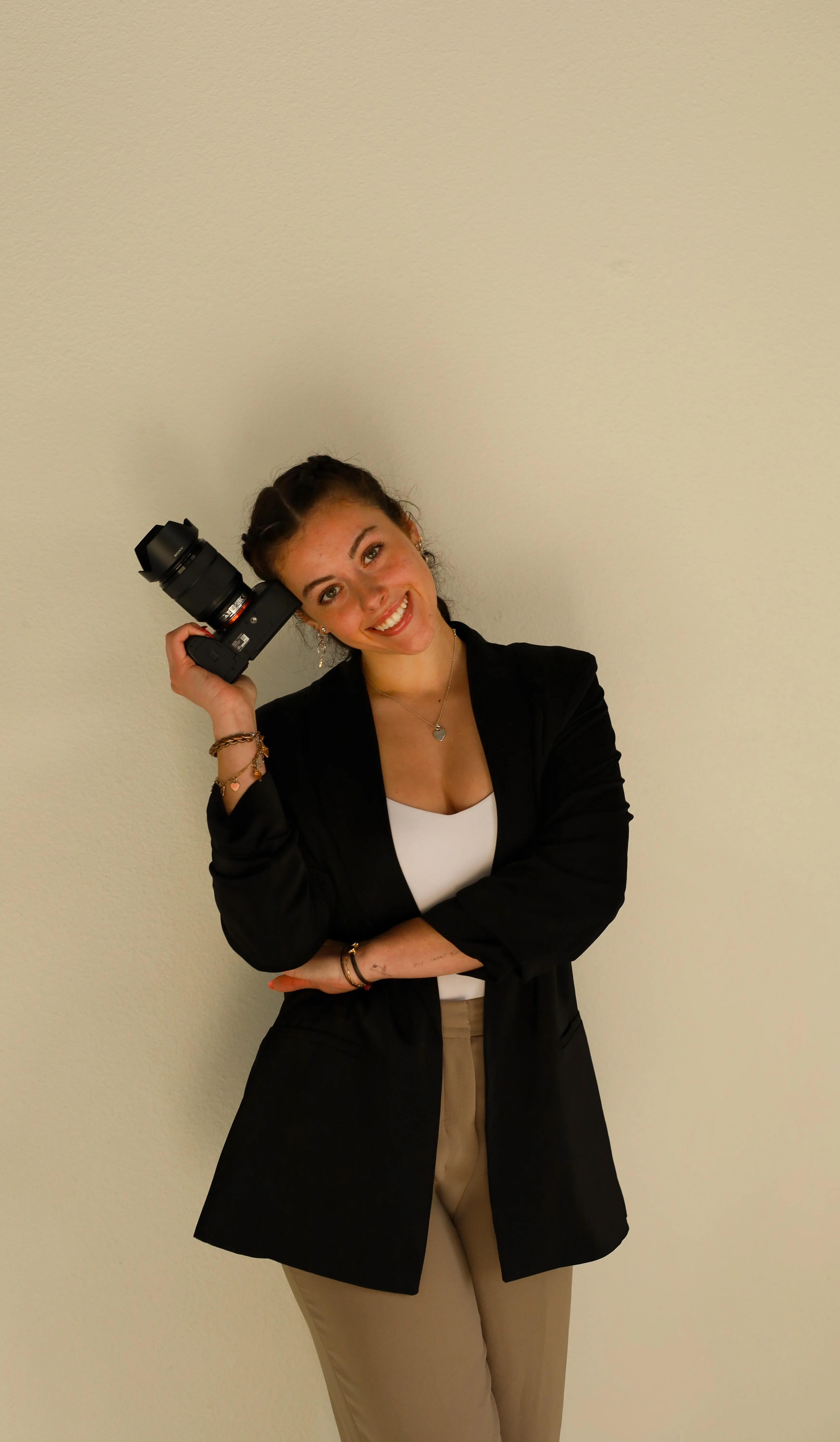 Baylie Mason, host of The Precision Pod, holding a camera